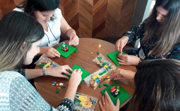 Pessoas "brincam" com peças de Lego durante treinamento corporativo que é tendência para 2020